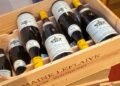 A wooden case filled with domaine leflaive puligny-montrachet grand cru bottles from the 2020 vintage, showcasing high-end biodynamic white burgundy wines.
